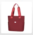 Detail of red water-resistant nylon tote bag with reinforced handles and metal logo - Red