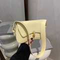 Schicke cremegelbe Leder-Unterarmtasche mit goldener Kapselschließe und breitem Gurt - Gelb