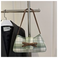 Detail der grün-weiß karierten Schultertasche mit brauner Lederschleife und Trageriemen - Grün
