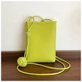 Dettaglio della mini borsa giallo lime in pelle martellata con tracolla a nodo - Verde