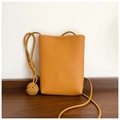 Close-up of ginger yellow leather mini crossbody bag with textured pebble grain finish - Yellow Brown