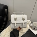 White faux leather crossbody bag featuring a metal star buckle and top handle - White