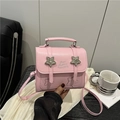 Pink leather crossbody handbag featuring metallic star ornaments and top handle strap - Pink