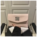 Vista de detalle del bolso sobre de charol rosa con logotipo SM de pedrería - Rosa