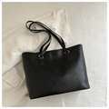 Detalle del bolso tote de cuero PU negro con herrajes dorados y letras sobre tela blanca - Negro