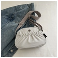 Light gray pleated crossbody bag with wide strap and metallic logo accent - Gray