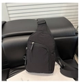Detail of waterproof black nylon crossbody bag showing the zipper and adjustable strap - Black
