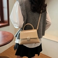 Grand sac cabas chic beige crème avec poignée et clous dorés porté par un modèle - Kaki