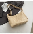 Detail of a beige textured faux leather hobo bag with stitching and wide shoulder strap - Yellow