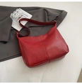 Detail view of large dark red leather hobo tote bag with wide strap and natural texture - Red