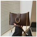 Detail view of brown leather bag with golden horseshoe buckle and chain strap - Brown