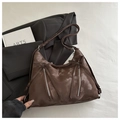 Macro view of dark brown bow detail and vintage oil leather texture on tote bag - Coffee