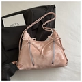 Close-up of pink satin handbag with bow knots and zippers on a grey blazer suit - Pink
