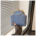Detailed close-up of blue denim crossbody bag with white embroidery and gold kiss-lock - Blue