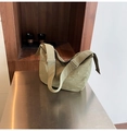 Detalle de bolso hobo de nailon verde oliva con correa ajustable sobre mesa plateada - Verde