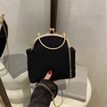 Elegante schwarze Handtasche mit Punkten, Goldkette und Metallgriff auf Spiegel - Schwarz