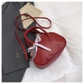 Elegante bolso rojo vino con colgante de lazo rosa y patrón texturizado en estudio - Rojo con colgante