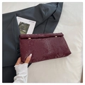 Detailansicht der dunkelroten Schlangen-Struktur-Clutch mit eleganten goldenen Verschlüssen - Rot