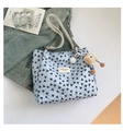 Macro shot of light blue tote bag with black bow print and plush cartoon charm detail - With Pendant / Blue