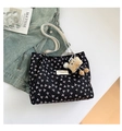 Close-up of black quilted tote bag with white bow prints and plush charm accessory - With Pendant / Black