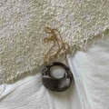 Mini-Handtasche in Halbmondform mit Faltenstruktur und Rundgriff in Bronzeoptik - Schwarz