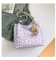 Close-up of lilac quilted tote bag featuring purple bow patterns and a cute plush charm - With Pendant / Purple