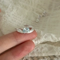 Detail van zilveren gegolfde ring met ovale blauwe zirkoon om de vinger - Verstelbaar open / Lichtblauwe Zirconia (Zilveren Band)