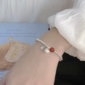 Perlenarmband aus Silber mit Fu-Anhänger und roter Achatperle am Handgelenk eines Models - Persimone Symbol Roter Achat Perlen