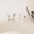 Boucles d'oreilles papillon en argent avec pierres fines sur un plateau en céramique - Argenté