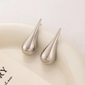 Polished silver teardrop earrings displayed on a minimalist ceramic plate background - Silver