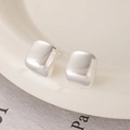 Macro detail of silver matte brushed cube studs on a minimalist ceramic plate - Brushed Silver (Silver Pin)