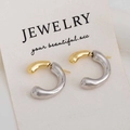 Detalle macro de pendientes de aro bicolores en forma de C con acabado en metal oro y plata - Oro Blanco