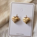 Orecchini a cuore in oro opaco spazzolato su espositore con sfondo in maglia - Clip per Orecchie a Cuore Spazzolato - Oro