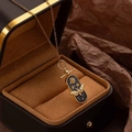 Detail of vintage gold bee necklace with oval rose pendant in a luxury jewelry box - Gold Black Bee Pendant Necklace