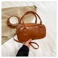 Detail of a brown vintage leather handbag with gold hardware on a white sheet - Brown