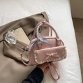 Pale pink leather square bag with lace trim, bow detail, and checkered ribbon on the handle - Pink