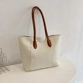 Bolso tote minimalista blanco marfil con asas de cuero marrón en un soporte moderno - Blanco
