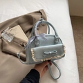 Light blue mini handbag featuring a lace pocket, bow detail, and checkered ribbon handle - Blue