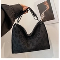 Grande borsa tote nera con motivi floreali a rilievo e tracolla in pelle morbida - Nero