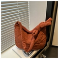 Détail du sac matelassé orange avec surpiqûres en cœur et bandoulière nouée - Orange