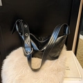 Schwarze glänzende Hobo-Tasche mit silbernen Ösen am breiten Schultergurt - Schwarz