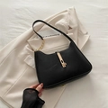Elegante borsa hobo nera a mezzaluna con fibbia dorata e tracolla su giacca chiara - Nero