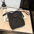 Minimalist black nylon drawstring bucket bag with adjustable straps in a modern setting - 19.5*15.5*5cm / Black
