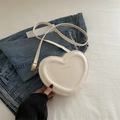 Chic white heart-shaped crossbody bag with gold lettering on a stylish denim background - Beige