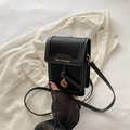 Piccola borsa a tracolla nera in ecopelle con ciondolo dorato su un blazer beige - Con Ciondolo / Nero