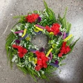 Primer plano de flores silvestres rojas y hojas de helecho en una corona de primavera - 50cm / Colorido