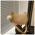 Detail of beige chevron-quilted crescent bag with golden chain and plush pompom charm - Khaki