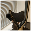 Close-up of black suede half-moon bag with V-quilted texture and gold chain strap - With Pom Pom Pendant / Black