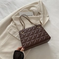 Borsa a tracolla marrone trapuntata con catena dorata su elegante blazer beige - Marrone