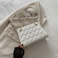 Borsa a tracolla bianca trapuntata con catena dorata su un blazer color beige - Bianco